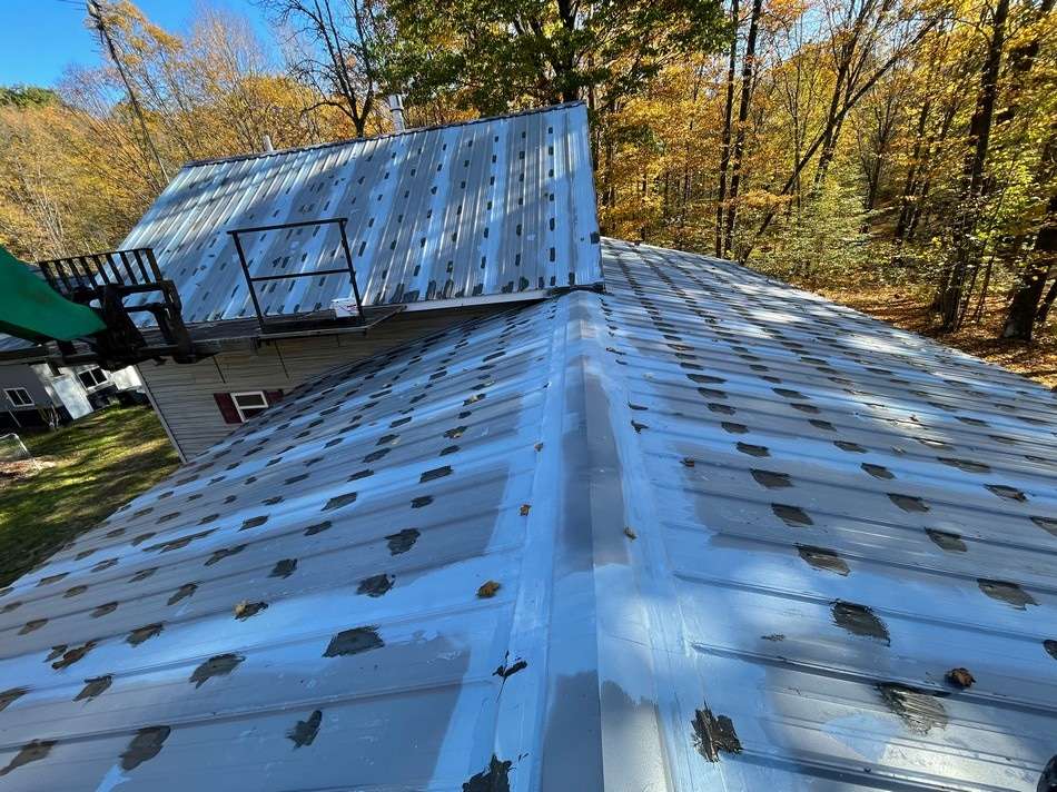Metal roof restoration in progress showing professional application techniques and quality workmanship