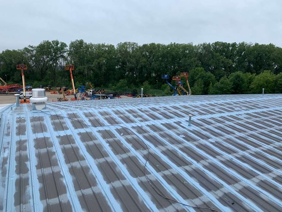 Metal roof restoration work demonstrating professional surface preparation and coating techniques